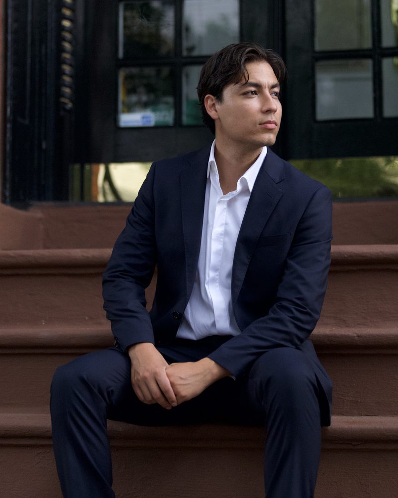Glenn Velasco seated on a brownstone stoop