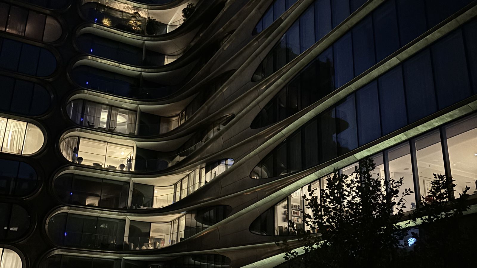 Facciata curva di un edificio residenziale illuminato di sera