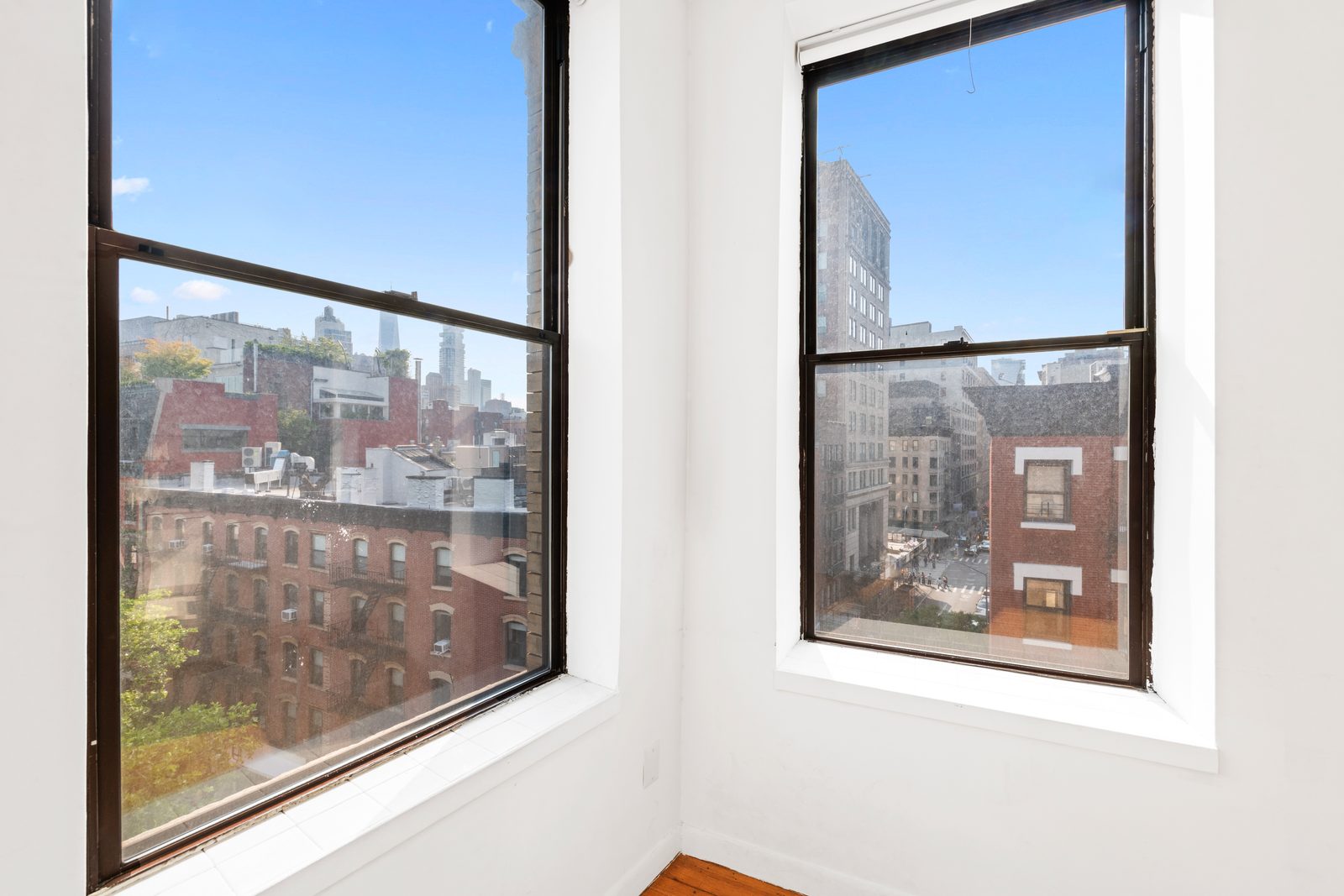 Two windows looking out over rooftops from 214 Mulberry Street in Nolita