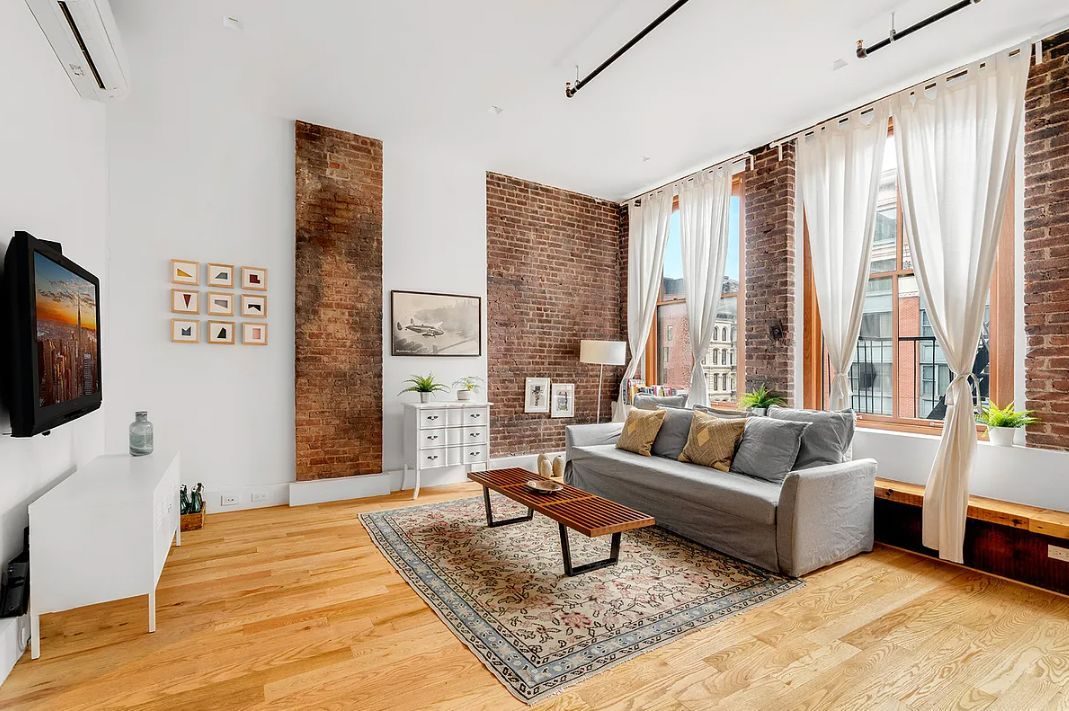 Loft living room with exposed brick and tall windows at 293 Church Street in Tribeca