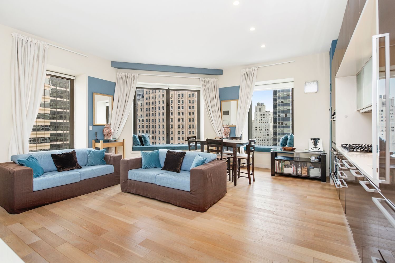 Living room with large windows and city views at 75 Wall Street in the Financial District